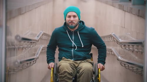 Man in Wheelchair Near Concrete Wall