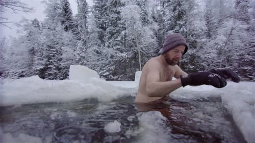 Man Enters Icy Lake in Winter Scene