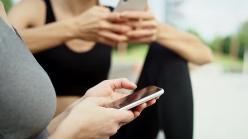 Close up video of two woman using mobile phone. Shot with RED helium camera in 8K.