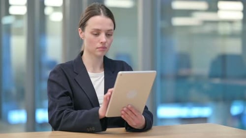 Young Adult Woman Using Tablet at Office Desk