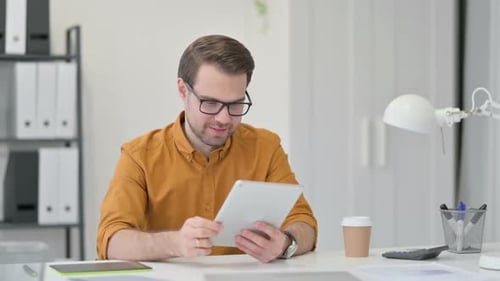 Man Receives Good News on Tablet in Office