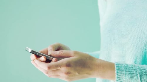 Woman sending tweets on smartphone