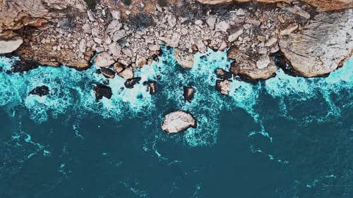 Luftaufnahme der Wellen brechen auf Felsen in einem blauen Ozean