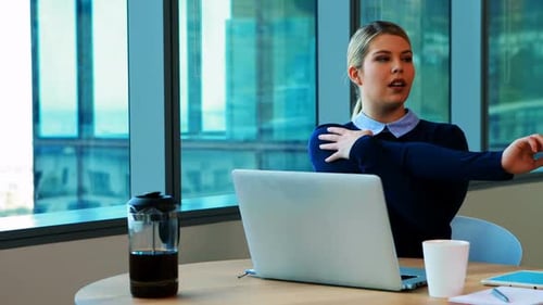 Female executive stretching her hands while working in office