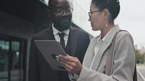Businesspeople with Tablet Discussing Work on Street