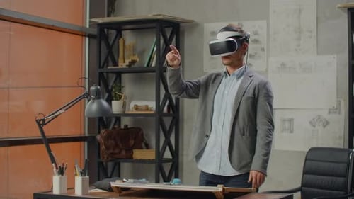 Male Architect in Office in Virtual Reality Helmet Uses Gestures to Manage a Project Without Leaving