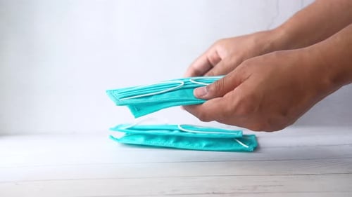 Man's Hand Holding Protective Face Mask Top Down