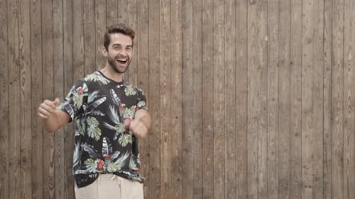 Man Giving Thumbs Up in Front of Wood Panel Wall