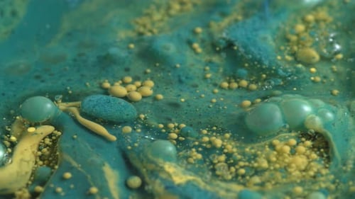Abstract close up texture of oil with blue and yellow paint, slow motion.