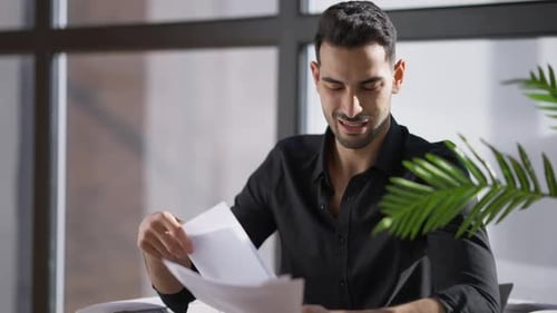 Angry Stressed Anxious Man Throwing Away Documents Sitting on Armchair at Window in Home Office