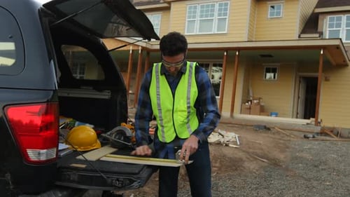 Construction worker cutting siding
