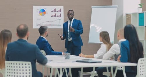 Black Director of the Company Tells the Flipchart to Employees About Strategy a Business Conference