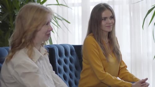 Seitenansicht von zwei Geschäftsfrauen, die drinnen mit jemandem sprechen