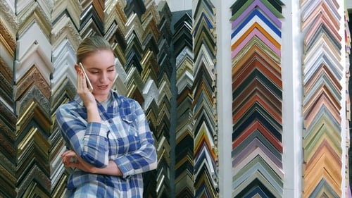 Woman Talking on Phone Shopping for Picture Frames