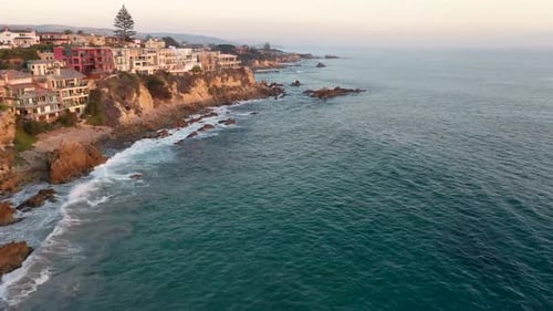 Flying over million dollar beach front luxury homes and the beautiful Laguna Beach California tide p