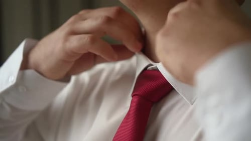 Man Adjusting Red Tie in Dress Shirt