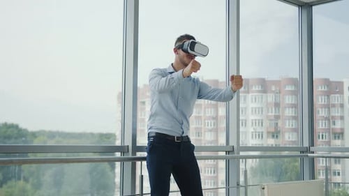 Close Up Young Man Sitting at a Desk in the Office Uses Augmented Reality Glasses To Work on