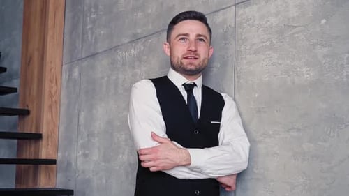 Young Adult Man Leaning Against a Wall Smiling