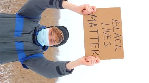 Young Adult Holds Black Lives Matter Sign in Snow