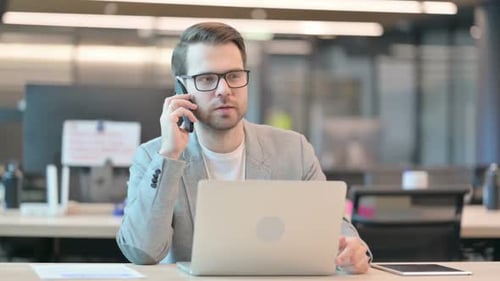 Professional Man Talking on Phone at Office Desk