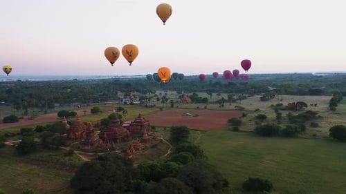 Sideway aerial shot of the hot air balloons floating over the temple in Bagan Myanmar