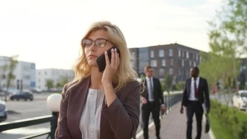 Businesswoman Talking on Phone While Walking in City