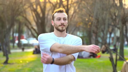 Man exercising in the park at sunset.