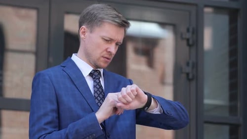 Man in Suit Checks His Wristwatch Outside