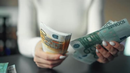 A Woman Is Holding Money and Counting Euro Bills