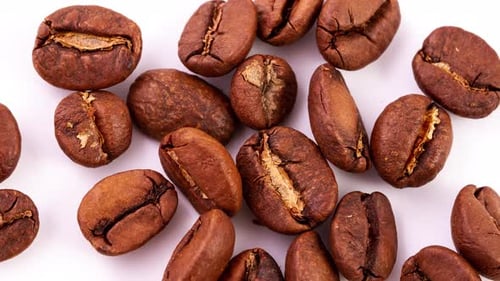 Geröstete reife braune Kaffeebohnen auf einem Haufen liegen auf weißem Hintergrund