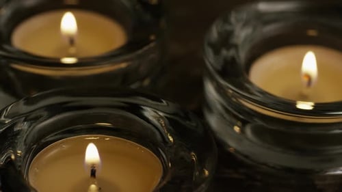 Glowing Candles in Glass Holders