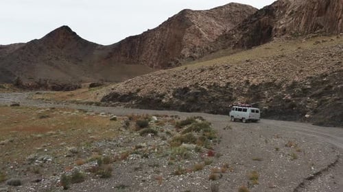 Offroad Vehicle Goes on a Dirt Road Among the Mountains