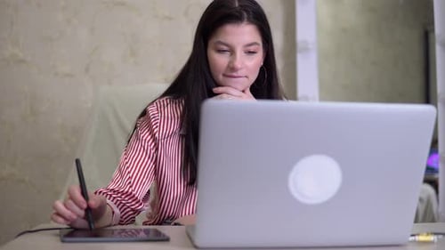 Woman Designer Distance Working Office Worker in Studio Using Tablet and Pencil