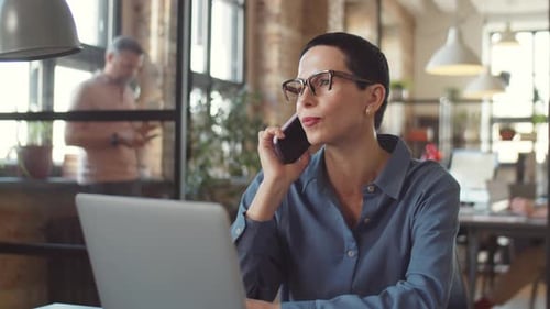 Elegant Businesswoman Talking on Phone in Office
