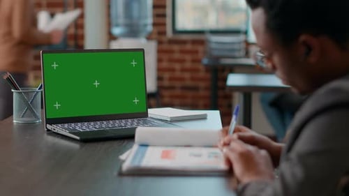 Young Adult Works at Laptop with Green Screen