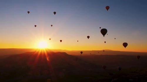 Hot Air Balloons at Sunrise Over Mountains