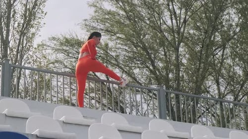 Young sports girl doing exercises on the street. Goes in for sports and fitness. Healthy lifestyle.