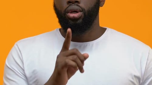 Young Bearded Male Showing Secret Gesture, Holding Finger Near Lips, Silence