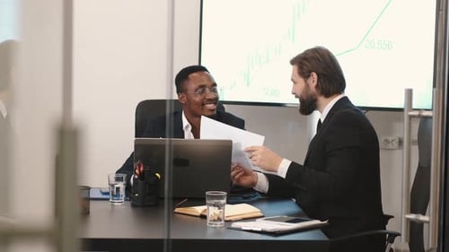 Two Businessmen in Suits Having a Discussion at Office