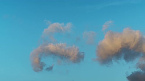 Fluffy Clouds Moving Slowly in a Blue Sky