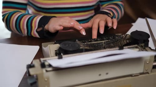 Hands of Woman Writing on a Vintage Typewriter