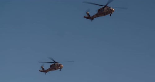 Military Helicopters Flying in Formation in a Blue Sky