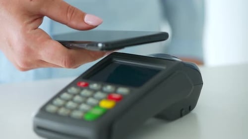 Hand Making Contactless Payment with Phone on Reader