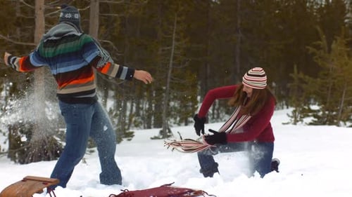 Couple Enjoying Fun Snowball Fight in Winter