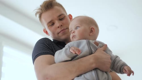 Father Holds Baby Gently Inside a Modern Home