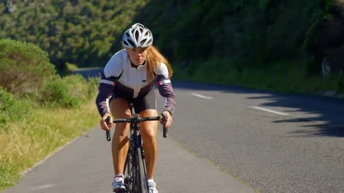 Female cyclist cycling on a countryside road