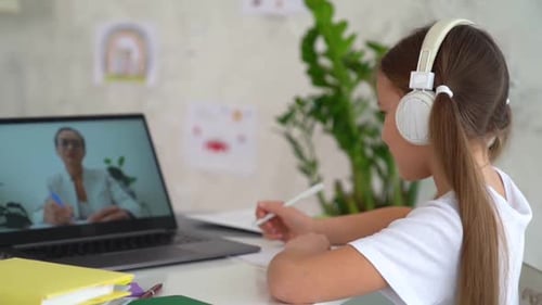 Girl Attends Online Class with Laptop and Headphones