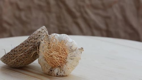 A garlic bulb and a basket on a wooden rustic board. Healthy food. dry garlic rotation