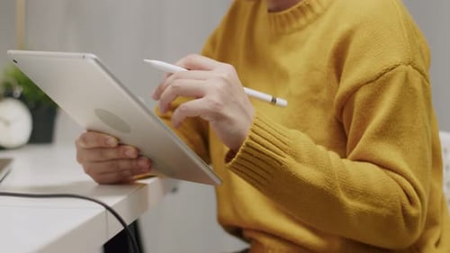 Woman Uses Stylus on Tablet at Desk