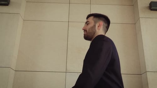 Glücklicher Geschäftsmann, der durch die Stadt läuft, erfolgreicher und selbstbewusster Mann im Hintergrund